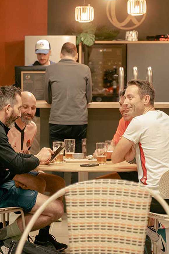 Personnes discutant autour d’un verre au club house de Pure Padel à Montaigu