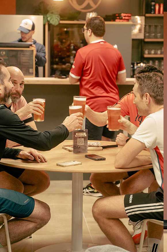Personnes trinquant autour d’un verre au club house de Pure Padel à Montaigu