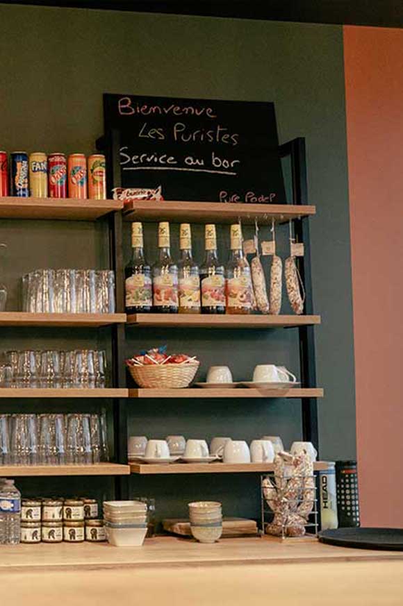 Bar du club house de Pure Padel à Montaigu avec étagères de verres et bouteilles