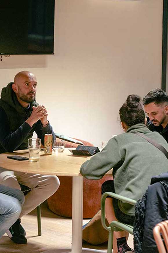 Personnes discutant autour d’une table dans le club house de Pure Padel en buvant un verre. La Roche sur Yon
