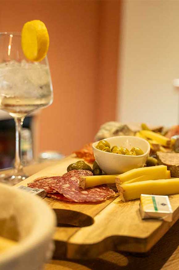 Planche apéritive de fromages et charcuterie avec cocktail dans le club house de Pure Padel à La Roche-sur-Yon et Montaigu