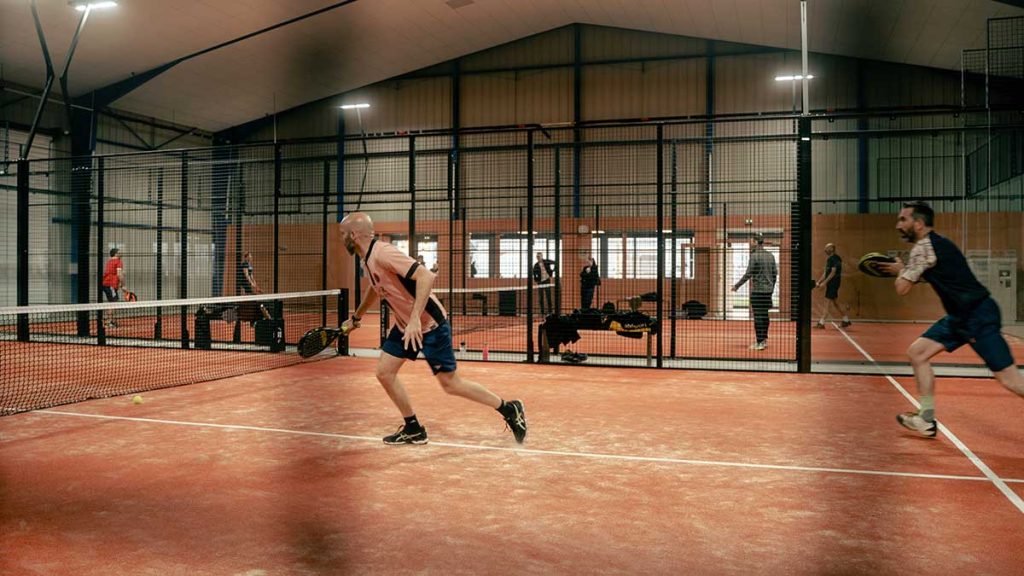Joueur en pleine action sur une piste de padel au complexe Pure Padel à Montaigu