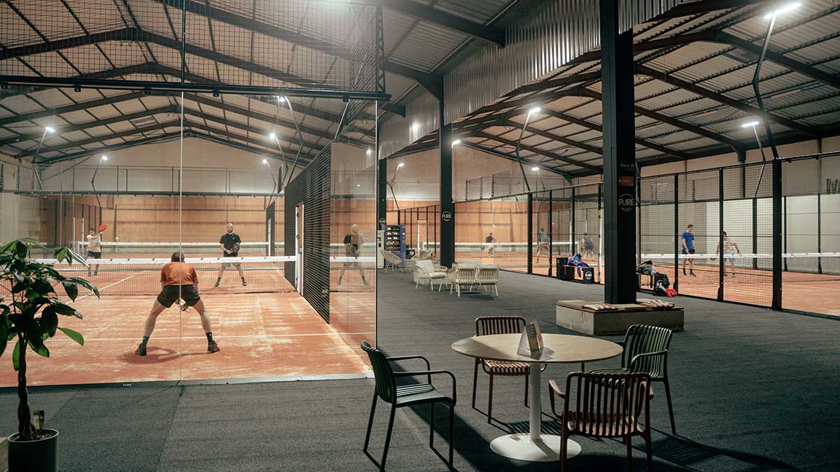Zone de détente du club Pure Padel à La Roche-sur-Yon avec vue sur les joueurs en action sur les pistes